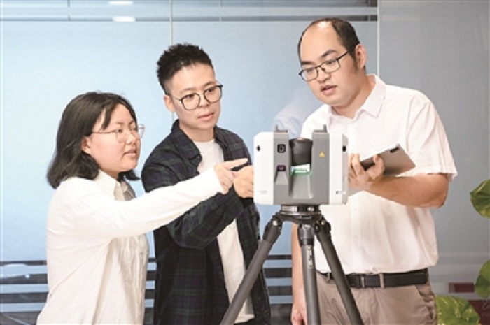 乔元辉向同事介绍三维扫描仪的使用方法