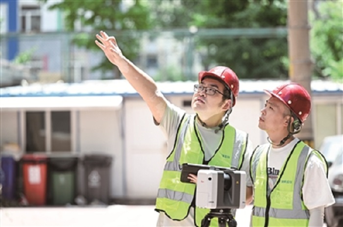 乔元辉与同事在建筑工地使用三维扫描仪，极大地提高了测量效率和精准度
