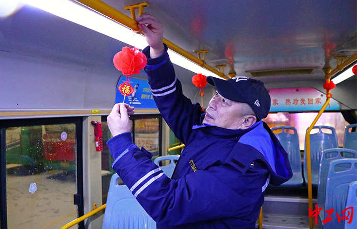 近日，怀务民正在布置春节主题车厢。青岛城运控股公交集团李沧巴士公司供图