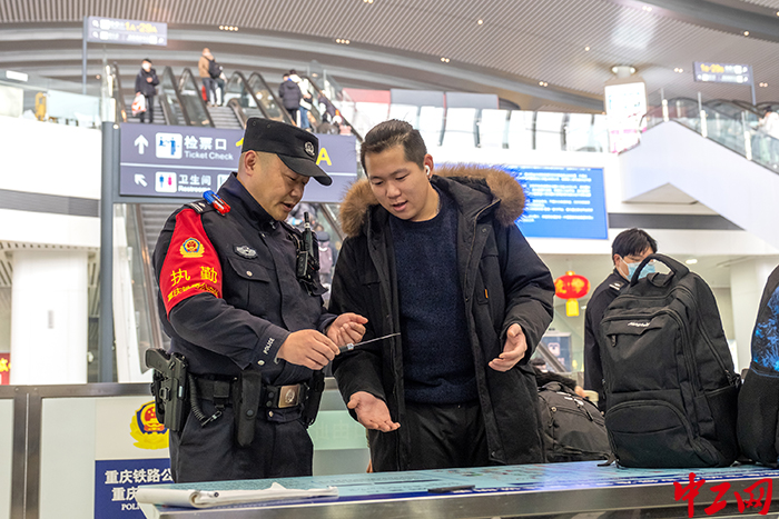 2月5日，在重庆西站东进站口，重庆西车站派出所民警牟浩向旅客开展安全乘车宣传。王新刚 摄