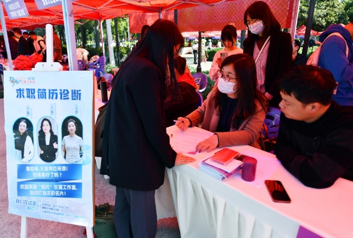 3月23日，老诚在招聘会现场为学生进行简历优化辅导。新华社记者王静颐 摄