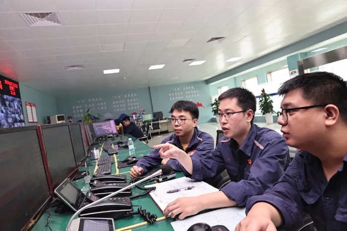 汪玉华（中）与同事讨论高炉操作参数。