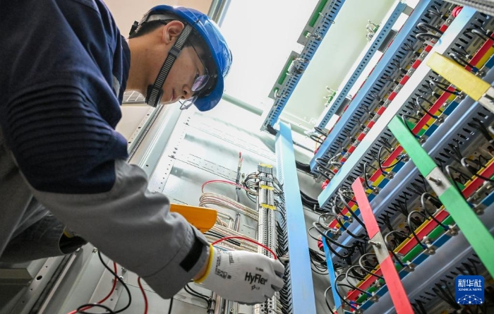 4月23日，在国网新源新疆阜康抽水蓄能电站地下厂房，设备管理部员工在工作前检查设备是否带电。新华社记者 陈朔 摄