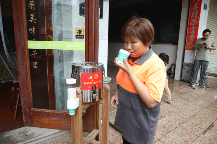 环卫工在文阿水丸店爱心饮水滴用水